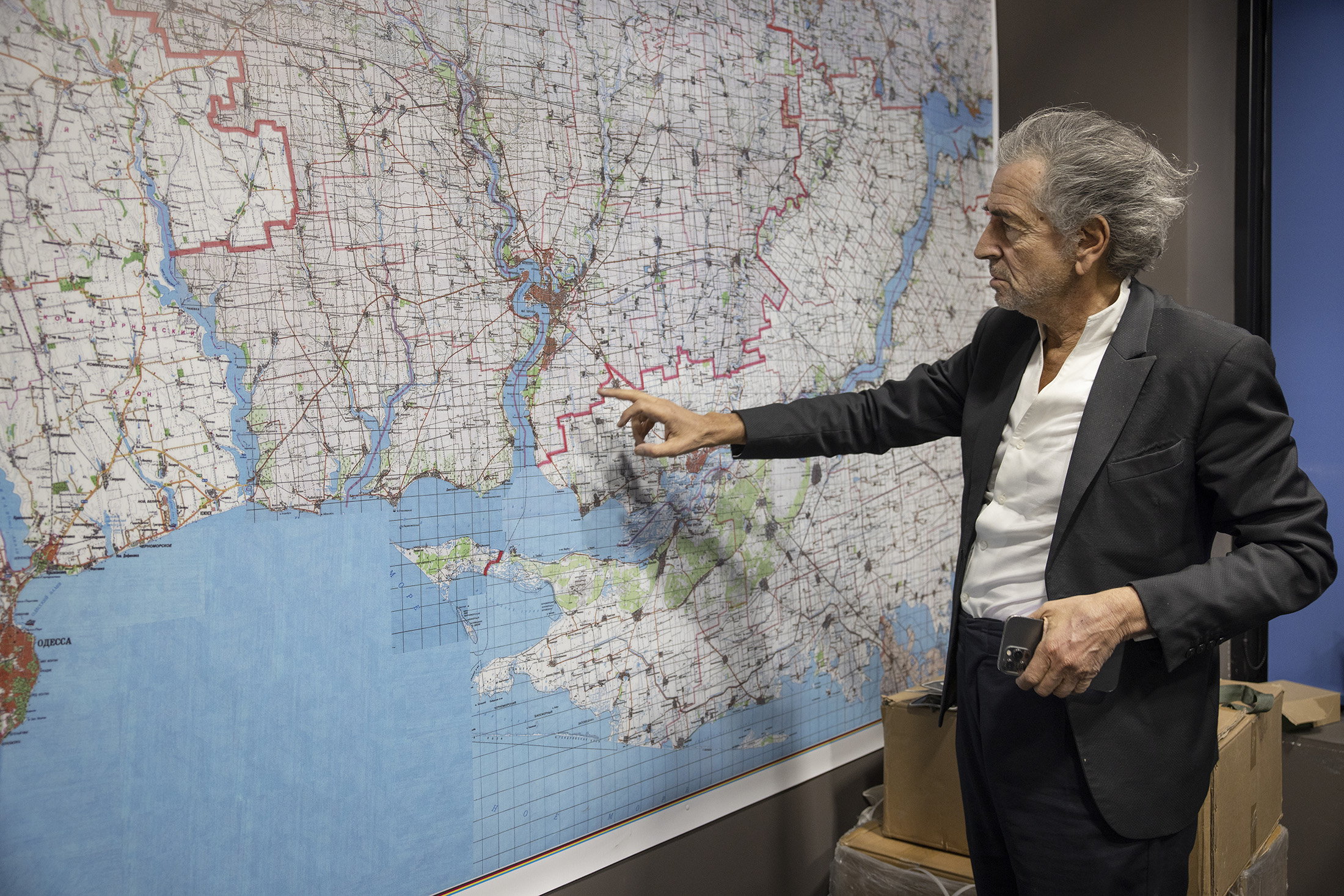 Bernard-Henri Lévy à Mykolaïv, dans un bureau face à une grande carte de l'Ukraine qu'il pointe du doigt.