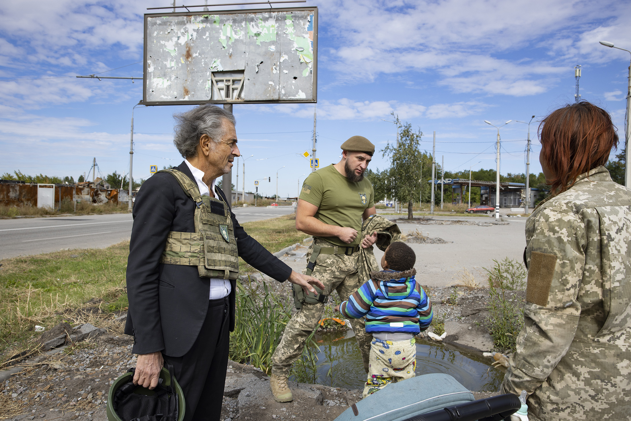 Bernard-Henri Lévy à Kharkiv avec des ukrainiens, une femme, un enfant et un homme.
