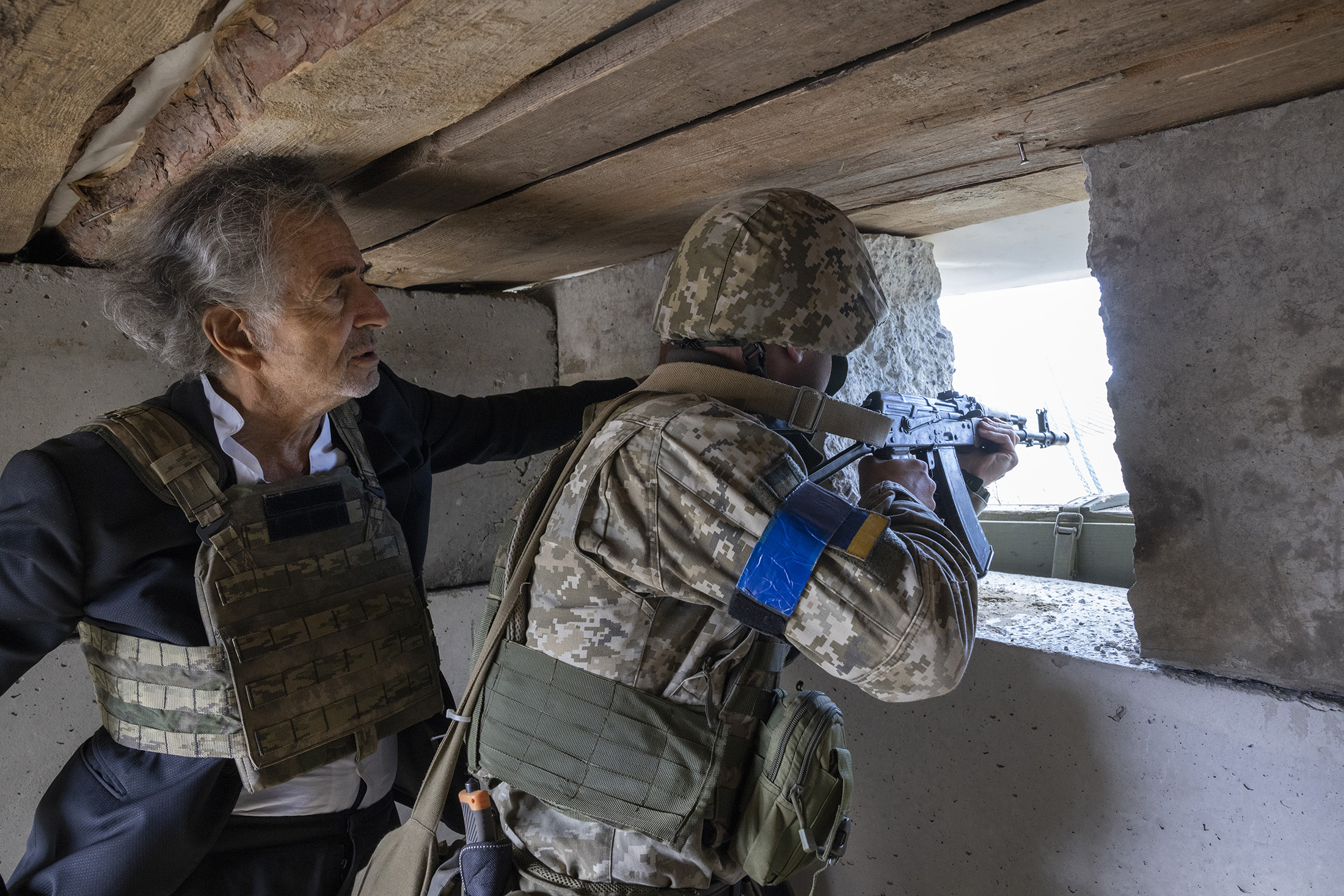 Bernard-Henri Lévy à Kharkiv, avec des militaires ukrainiens. BHL observe un militaire en train de tirer avec une arme.