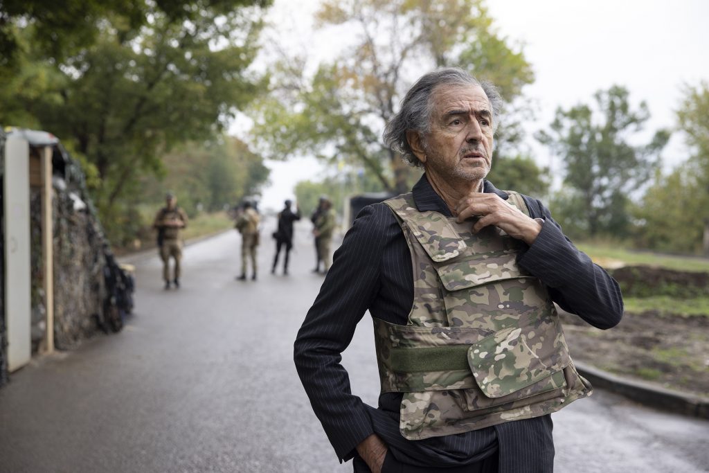 Bernard-Henri Lévy à Lyman, en Ukraine, sur une route près d'un check point, il porte un gilet militaire.