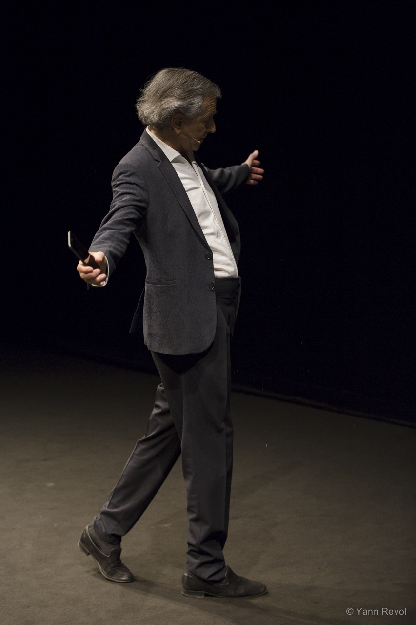 Bernard-Henri Lévy joue « Looking for Europe » à Copenhague. BHL est debout sur une scène de théâtre.