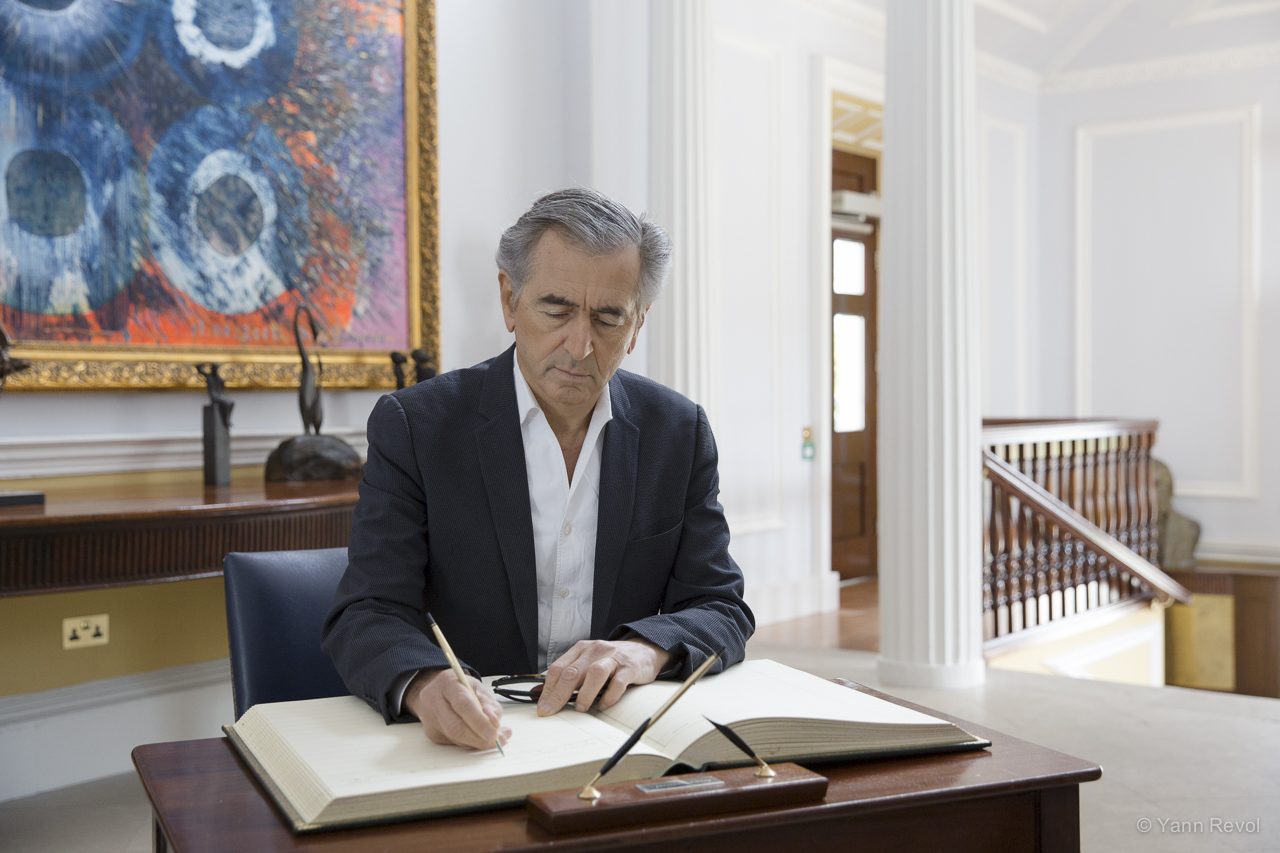 Bernard-Henri Lévy signe un livre d'or au palais présidentiel de Dublin.