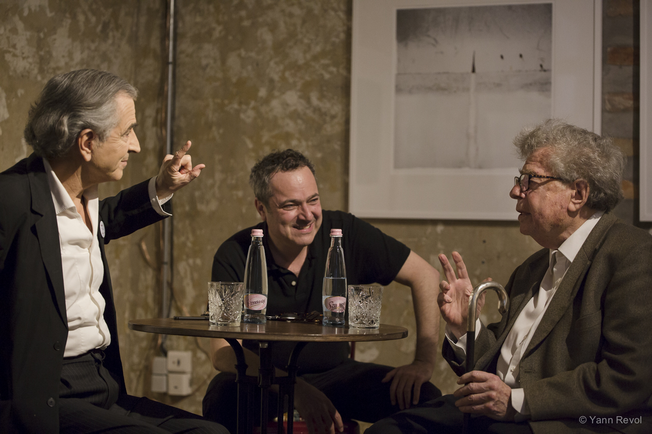 Bernard-Henri Lévy, Balazs Gera et Gyorgy Konrad sont assis autour d'une petite table ronde, ils parlent.