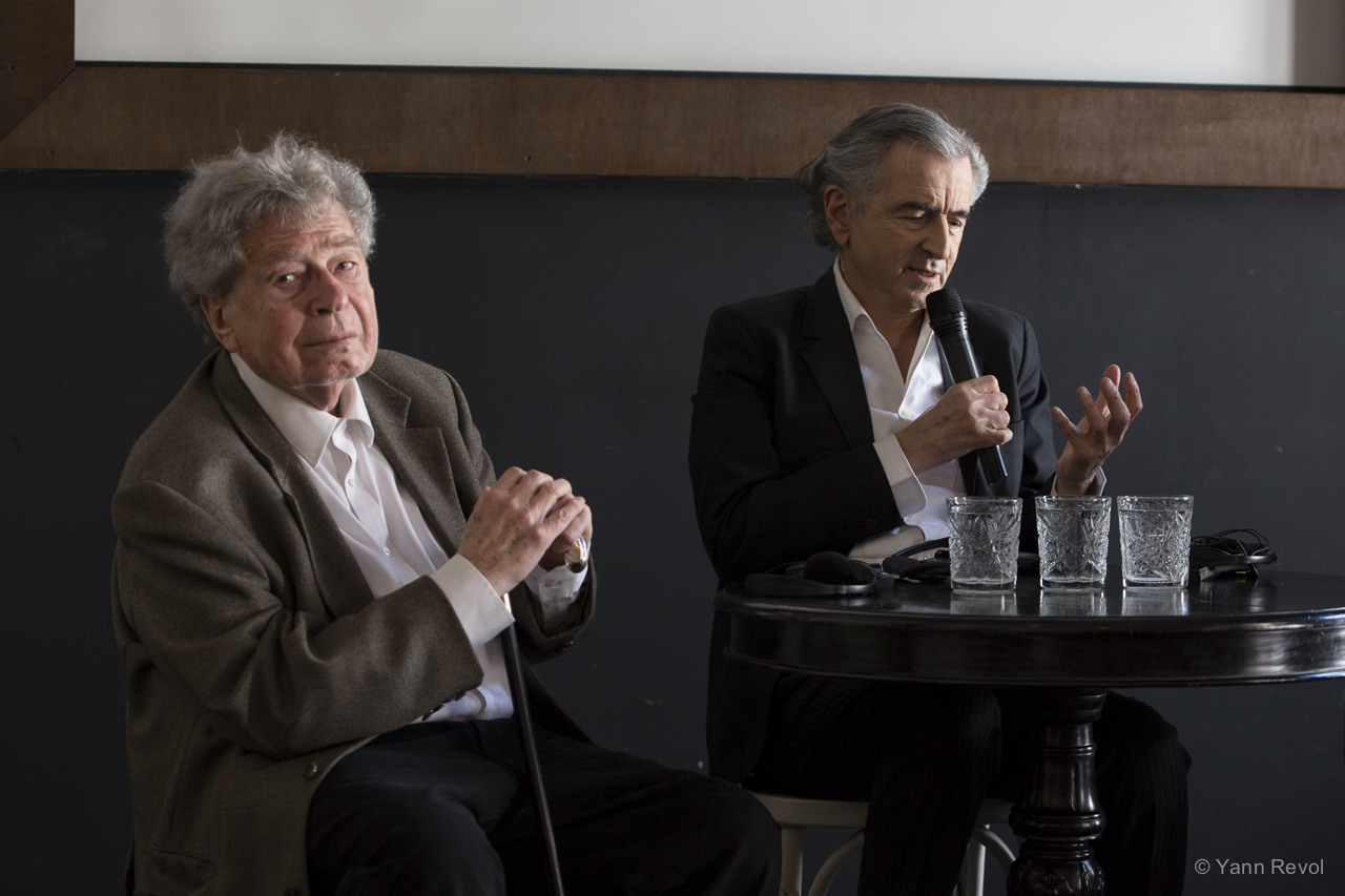 Gyorgy Konrad et Bernard-Henri Lévy donnent une conférence de presse, ils sont assis côte à côte derrière une petite table ronde, BHL parle dans un micro.