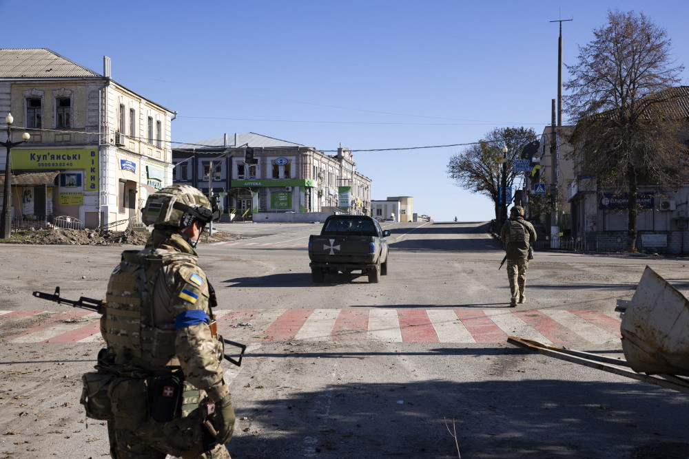 Deux militaires et un pick up dans les rues désertes de Koupiansk.