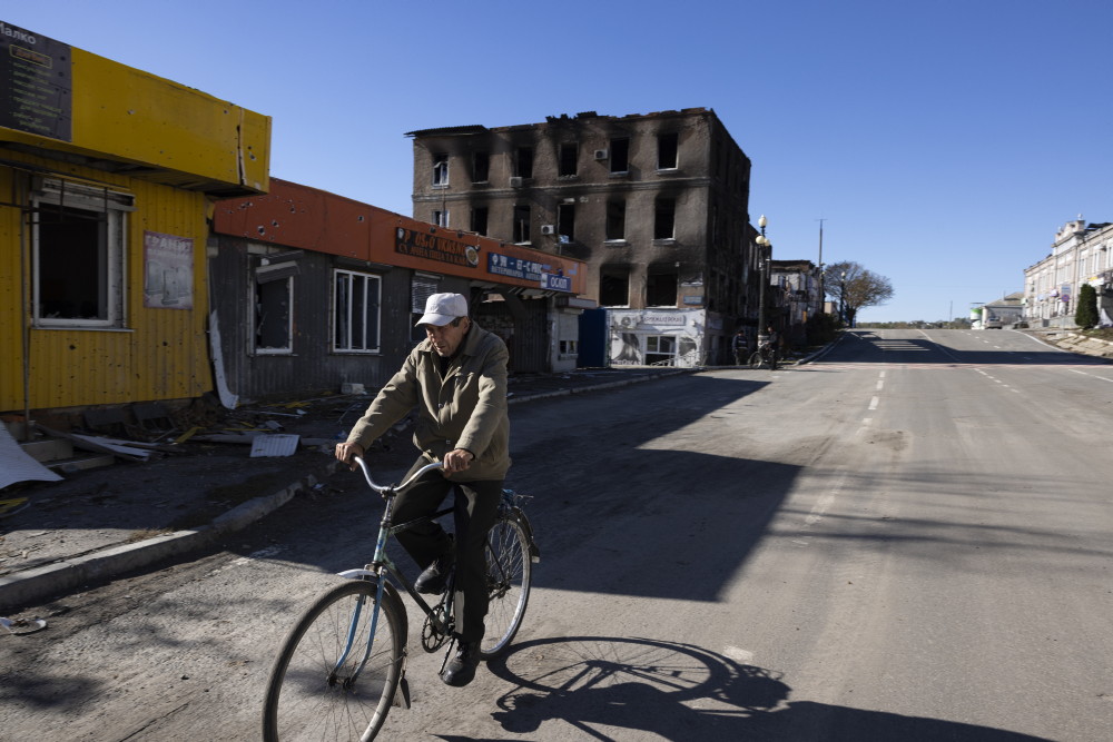 Un homme fait du vélo dans une rue de Koupiansk en Ukraine.