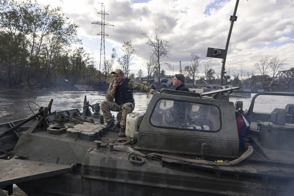 Des militaires sur un tank chargé sur une barge d'acier pour traverser le Donest.