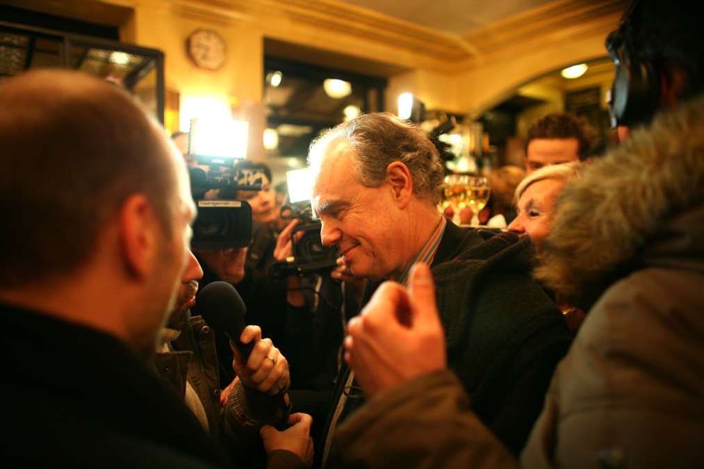 Frédéric Mitterrand au Café de Flore. Il répond à des journalistes massés autour de lui.