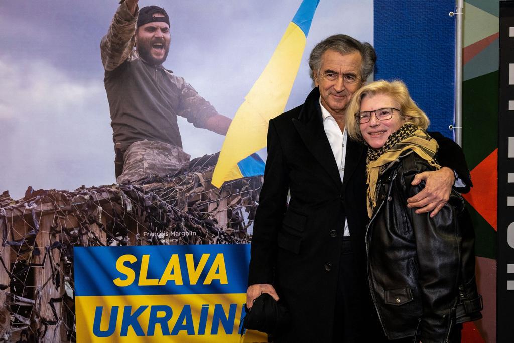 Bernard-Henri Lévy et Yulia Paevska alias « Taïra », lors de la projection dans un cinéma de Kiev du film de BHL « Slava Ukraini ». Ils posent devant l'affiche du film.