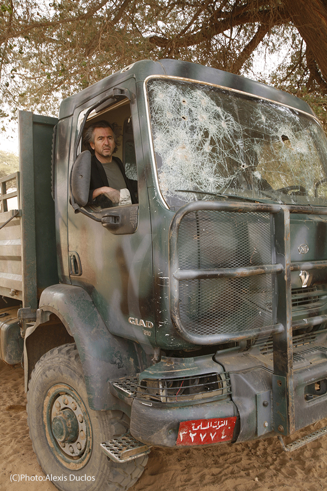 Bernard-Henri Lévy au Darfour/Soudan près du Djebel Marra, dans un camion fabriqué au Soudan et pris par les combattants de l'ALS. La vitre du pare-brise est brisée.