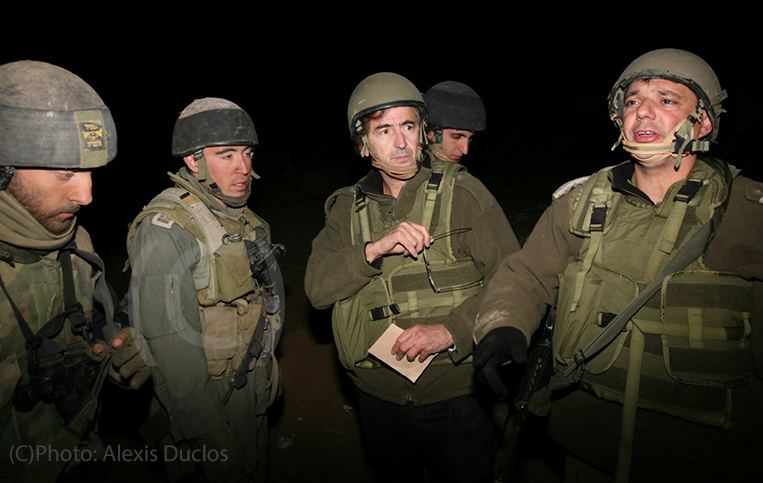 Bernard Henri Lévy avec des soldats Israéliens, la nuit. Ils portent tous des uniformes militaires