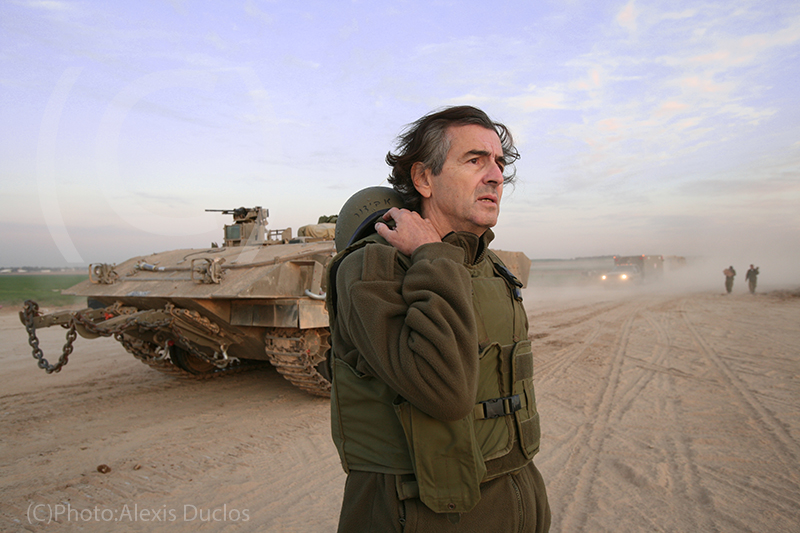Bernard-Henri Lévy au cœur de l’opération « Plomb durci » à Gaza le 13 janvier 2009. Il porte un uniforme militaire, derrière lui on voit un tank.