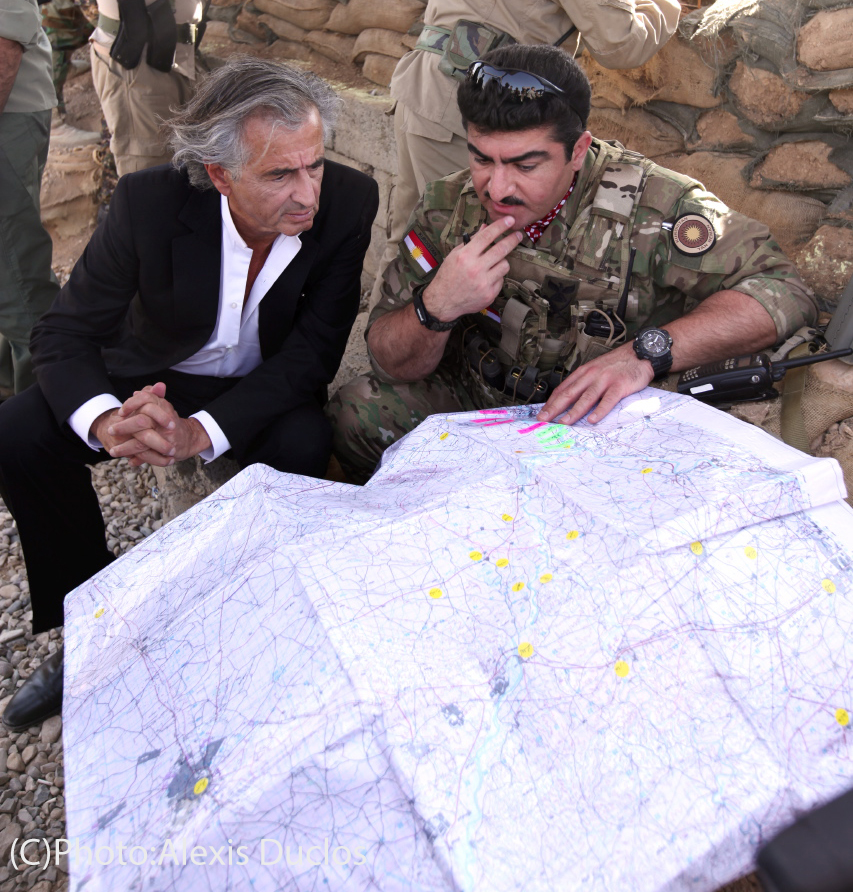 Bernard-Henri Lévy et Sirwan Barzani au Kurdistan irakien ; ils sont accroupis devant une carte géographique.