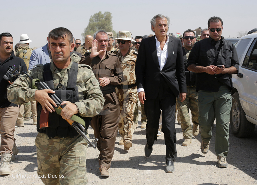En août 2015 BHL se rend à Kurdistan irakien, auprès des Peshmergas. BHL est entouré part des militaires, ils marchent au milieu d'une route.