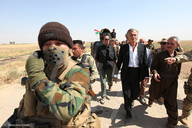 En août 2015 BHL se rend à Kurdistan irakien, auprès des Peshmergas. BHL est entouré part des militaires, ils marchent au milieu d'une route.