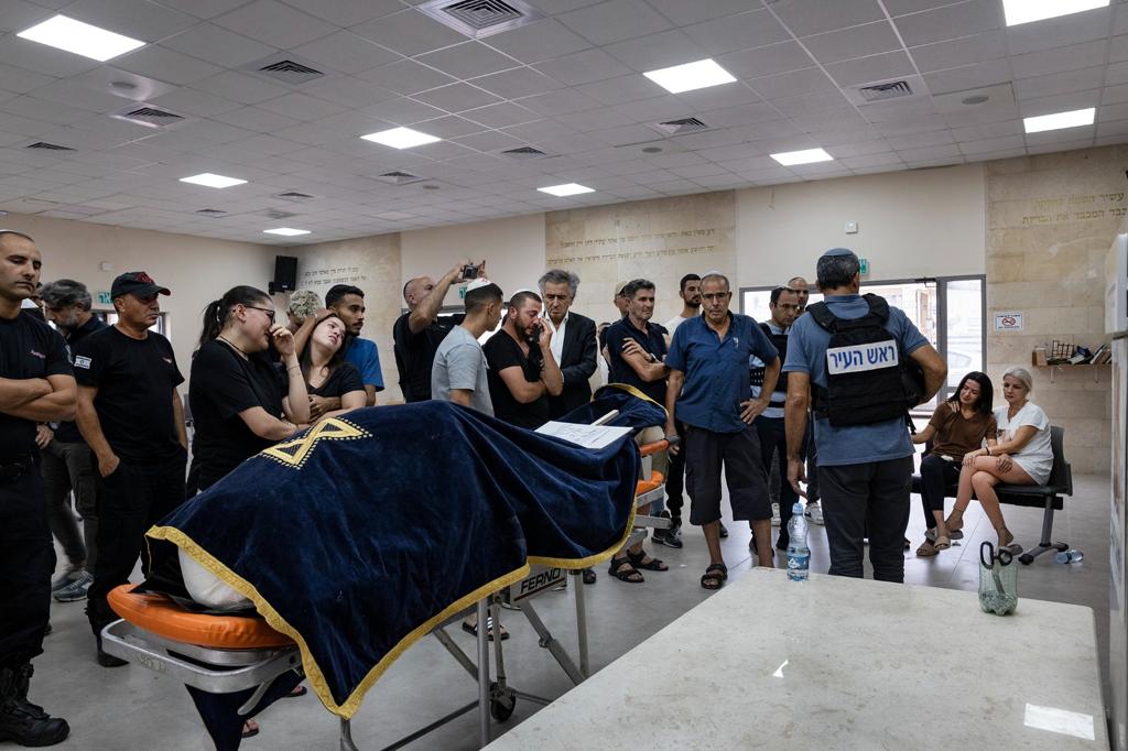 Bernard-Henri Lévy lors des funérailles du chef des pompiers de Sderot. Devant le corps du défunt , recouvert d'un linceul, il est avec les membres de la famille et de l'entourage qui pleure.