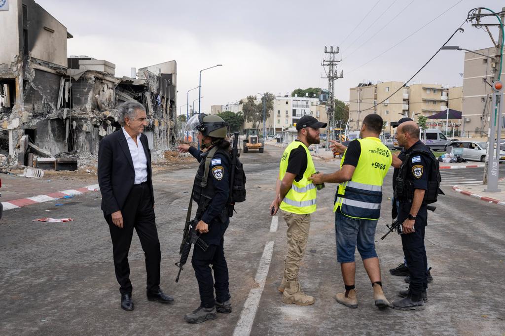 Bernard-Henri Lévy à Sderot, devant un batîment en ruines il parle avec des militaires.