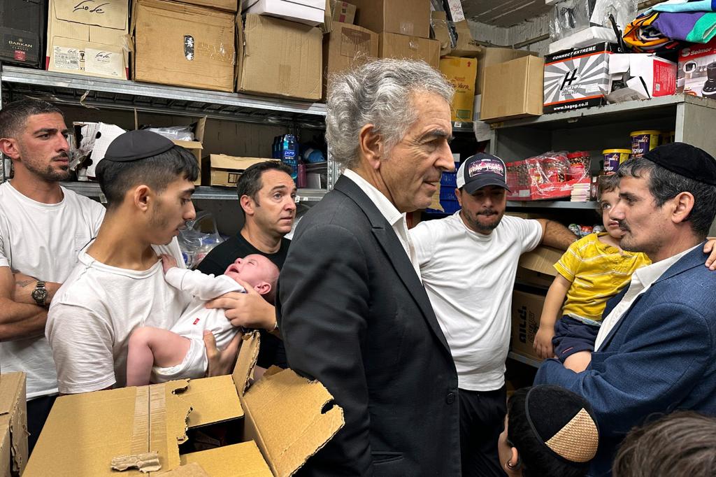 Bernard-Henri Lévy et un jeune israélien dans une cave pleine de nourriture et de denrées.