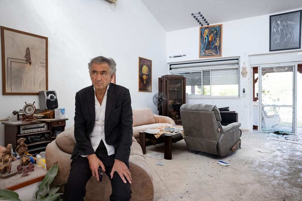 Bernard-Henri Lévy assis dans le salon d'une maison déserte, criblée de balle. Une maison dont les habitants ont été assassinés.