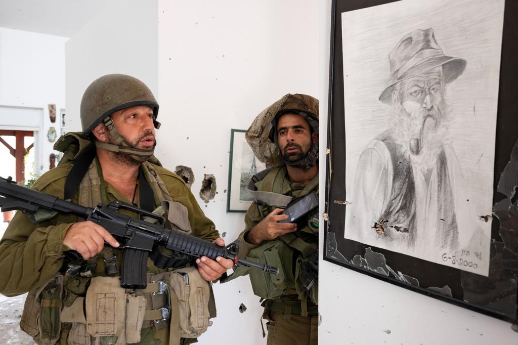 Dans une maison déserte dont les habitants ont été assassinés. Deux soldats israélien face à un portrait de vieux monsieur au fusain.