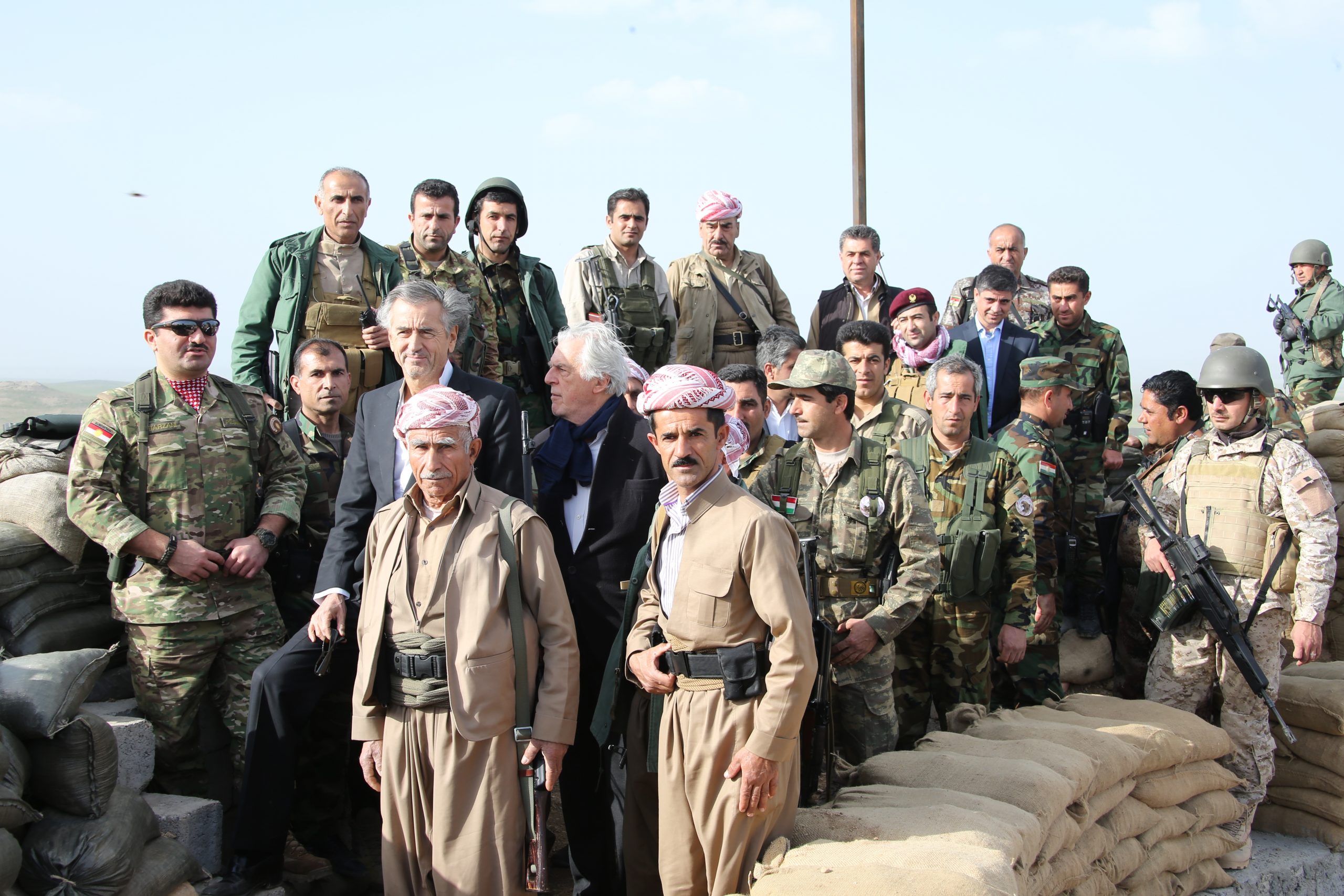 Bernard-Henri Lévy, Gilles Hertzog, et le général Barzani avec ses hommes en tenue militaire.