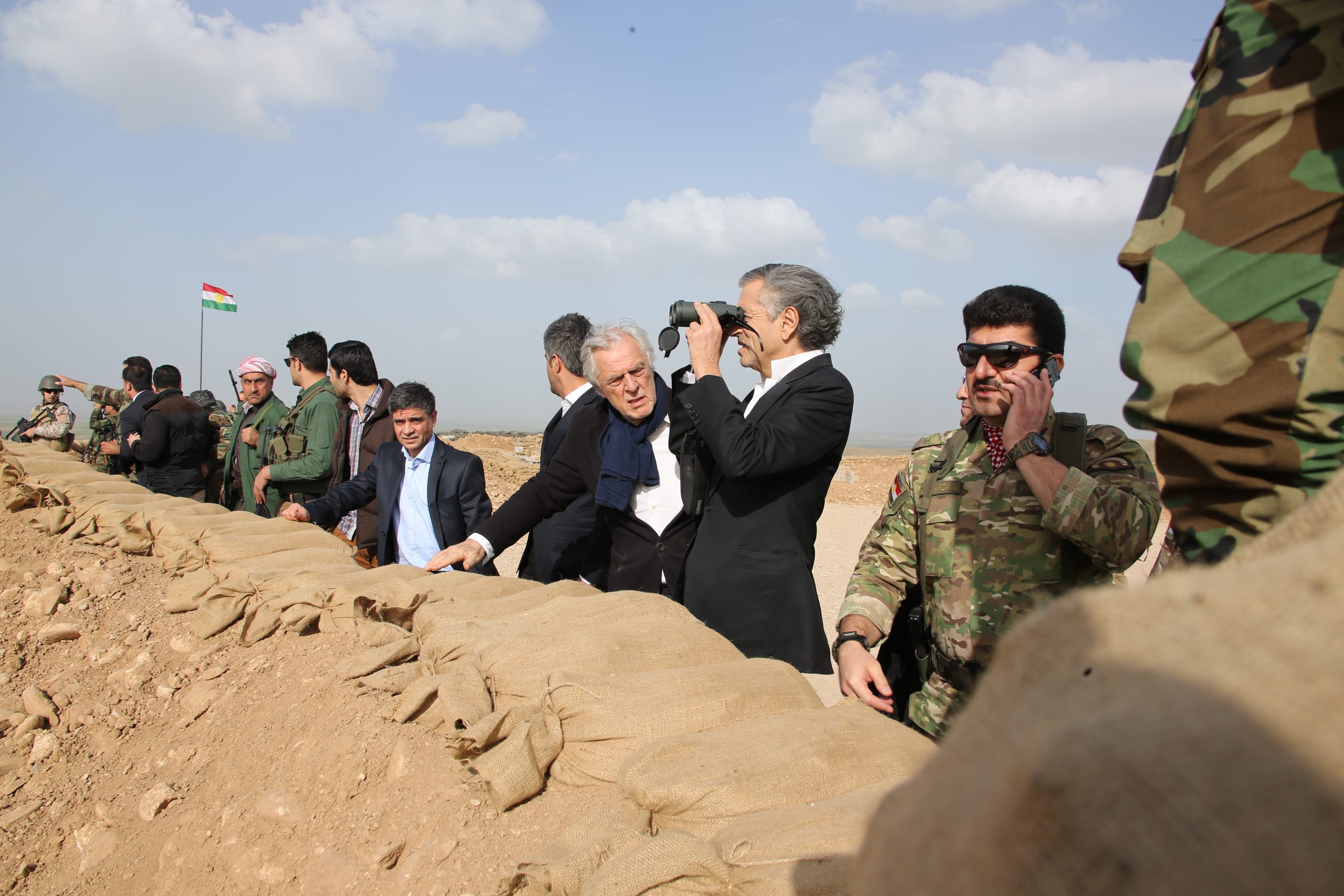 Bernard-Henri Lévy et Gilles Hertzog au Kurdistan irakien, avec les combattants Peshmergas du général Sirwan Barzani. Ils sont sur la ligne de front, BHL regarde dans des jumelles.