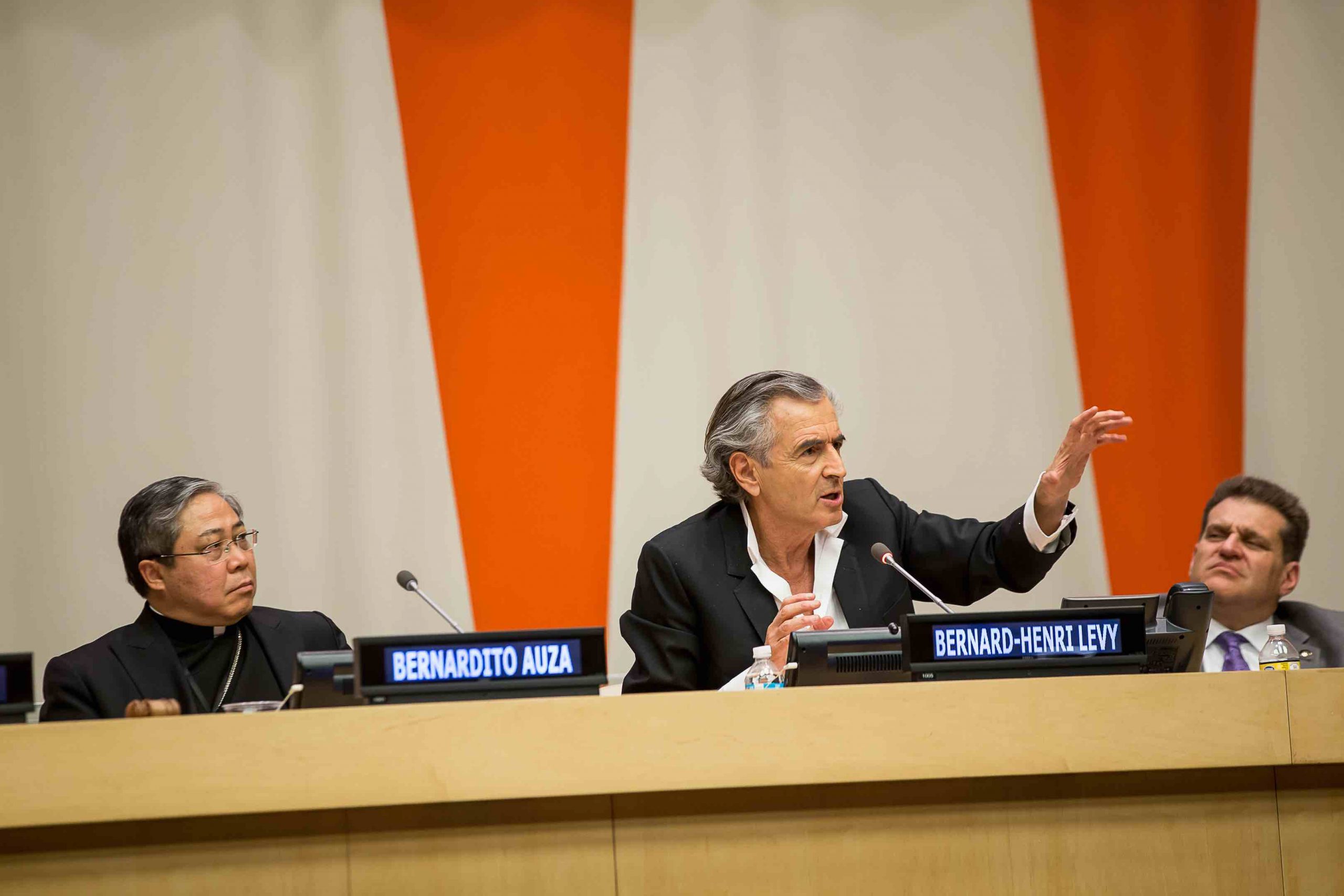 BHL et Bernardito Auza à l'ONU en 2015. Ils sont assis derrière une grande table de conférence avec des micros.