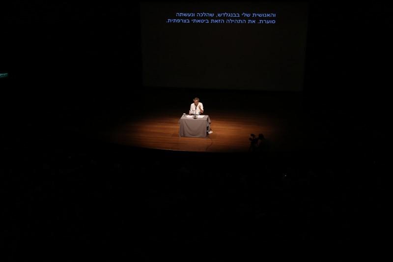 Bernard-Henri Lévy lit des extraits de son livre, « L’Esprit du Judaïsme », au Musée d’Art de Tel-Aviv. Il est seul sur scène, assis derrière une table, et il parle dans un micro.