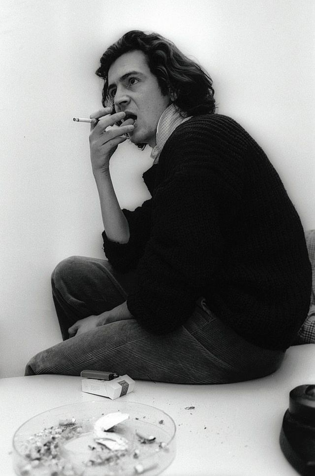 Bernard-Henri Lévy fume une cigarette. Photo en noir et blanc.