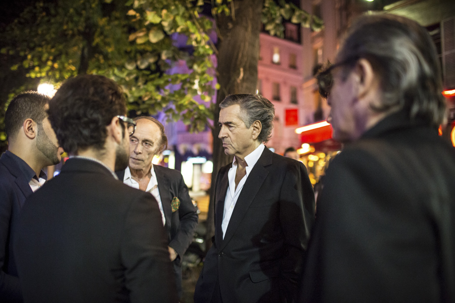 Bernard Schalscha et Bernard-Henri Lévy. Ils parlent devant le Théâtre du l'Atelier avec trois hommes qu'on voit de dos.