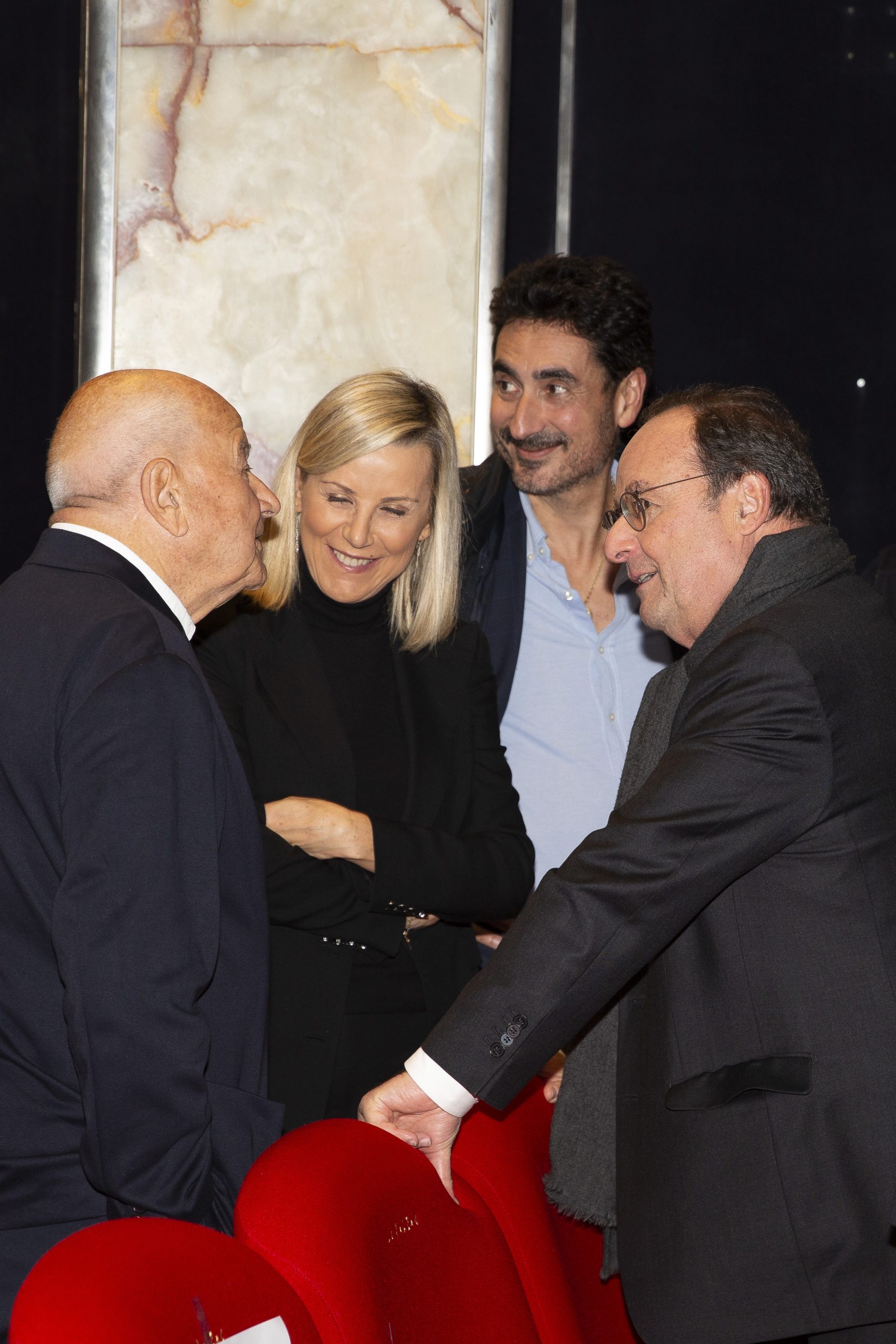 Laurence Ferrari et François Hollande parlent avec deux autres personnes dans la salle du cinéma le balzac
