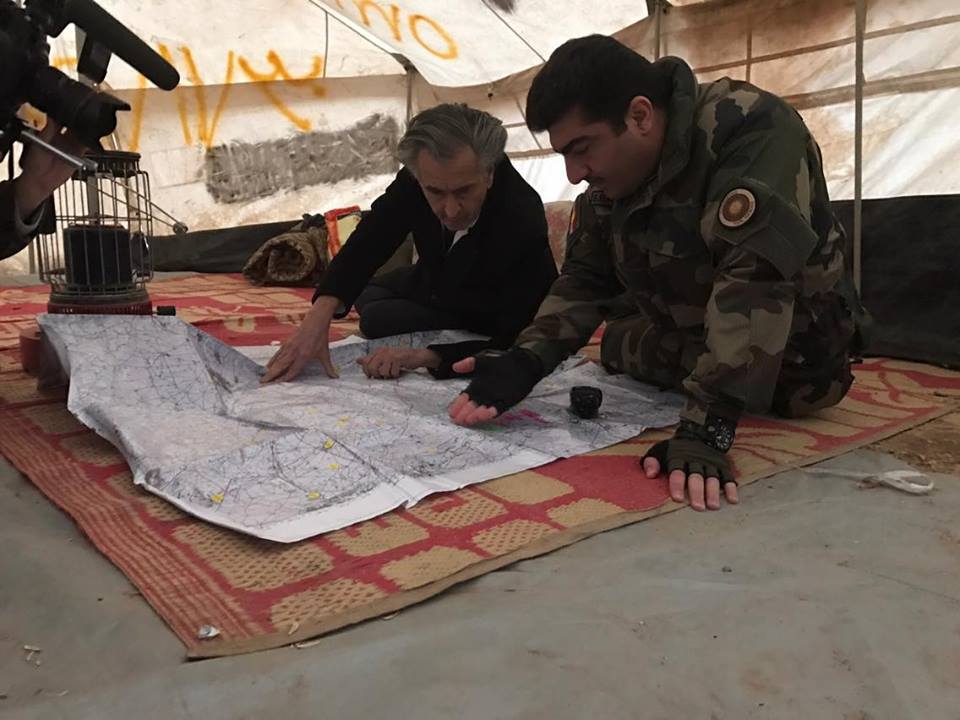 Bernard-Henri Lévy et Sirwan Barzani. Ils sont assis par terre dans une tante, ils se penchent sur une carte posée au sol.
