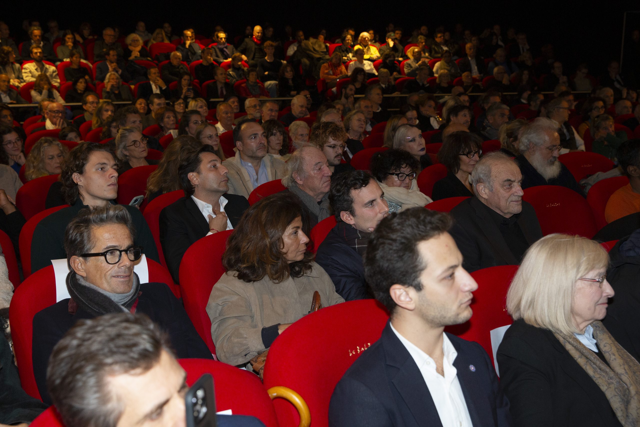 Le public du Balzac pour « L'Ukraine au coeur » de BHL, la salle est pleine tout le public est assis dans des fauteuils rouges.