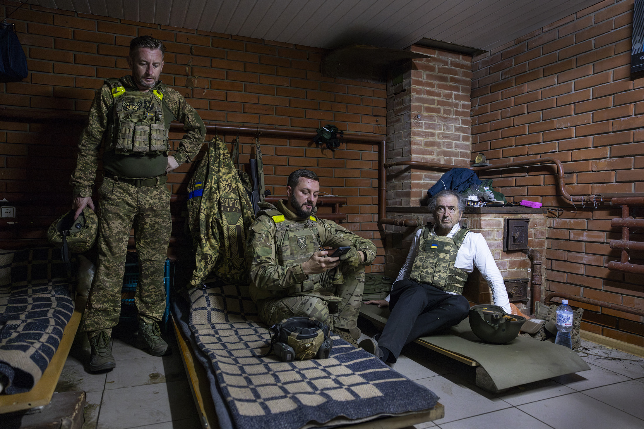 BHL est avec les troupes de la Brigade Khartia dans un bunker de Kharkiv. Ils sont assis sur des matelas posés sur le sol.