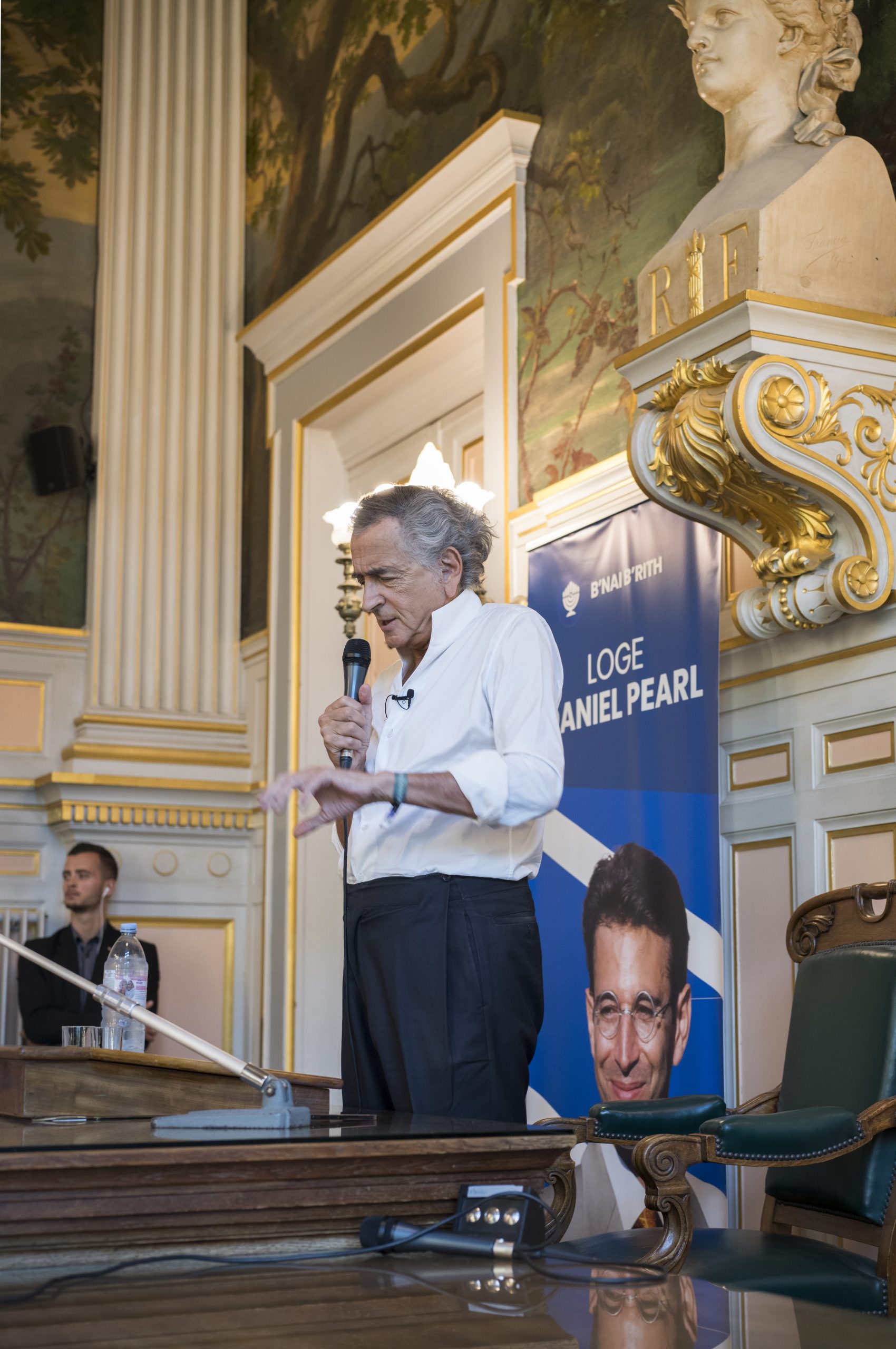 BHL parle dans un micro il donne une conférence devant une salle comble de la mairie du 16eme arrondissement de Paris