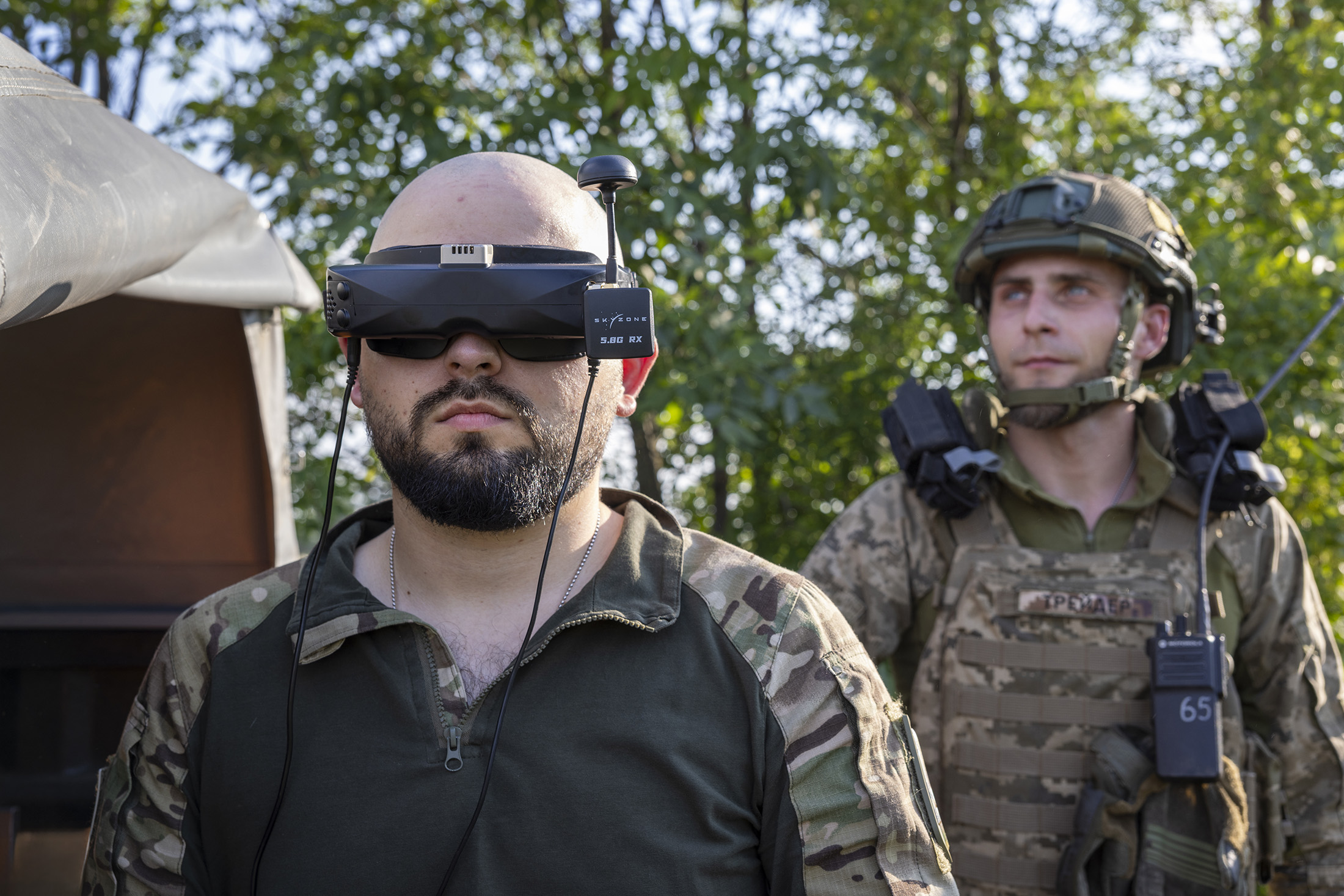 un soldat pilote un drone, il porte un casque de pilotage de drone.