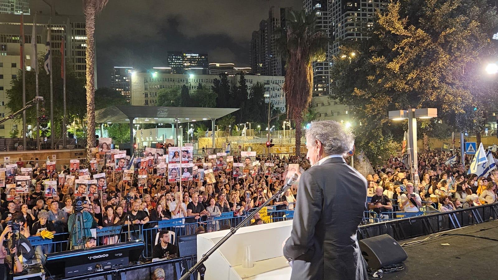 Bernard-Henri Lévy fait un discours sur la Place des Otages à Tel-Aviv, en Israël, le 11 mai 2024. Il parle face à une foule brandissant des pancartes avec les visages des otages israéliens.